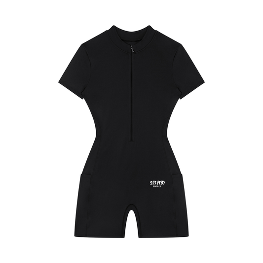 A black short-sleeve one-piece swimsuit with a half-zip front, high mock neck, and side pockets, featuring a small white logo on the lower left leg, shown against a plain white background.